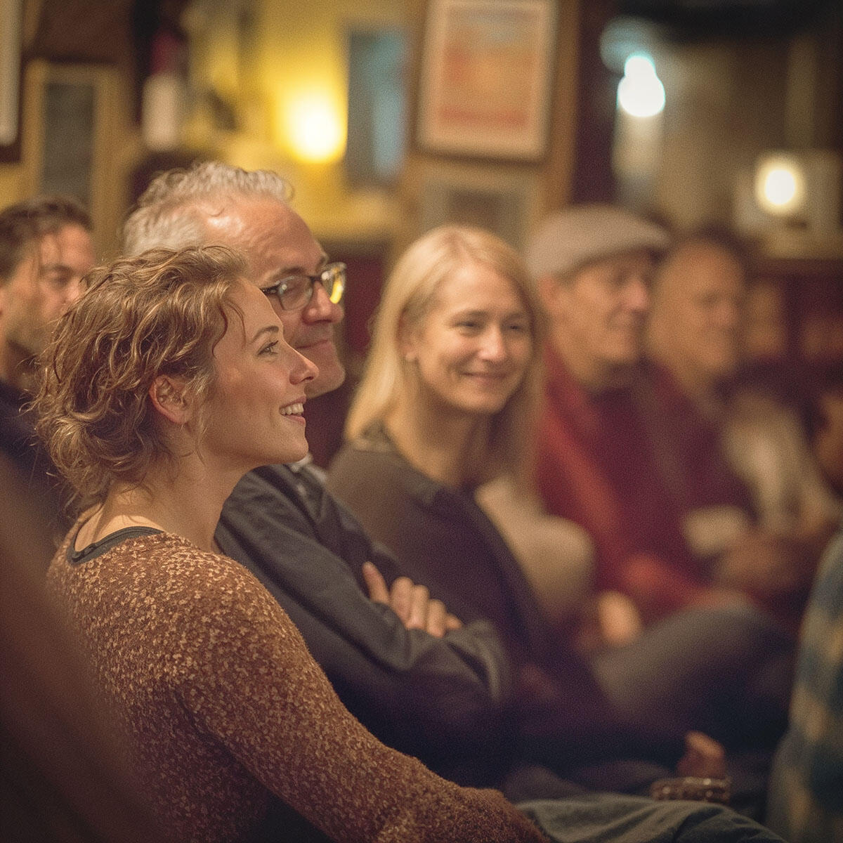 Audience smiling and applauding at an intimate acoustic performance in Kansas